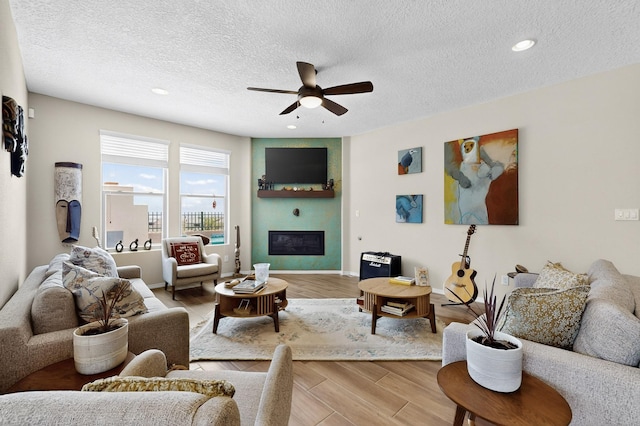 6417 Kings Cyn NE, Rio Rancho, NM 87144 - living room featuring a ceiling fan, a textured ceiling, light wood-type flooring, recessed lighting, and a glass covered fireplace