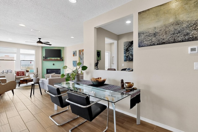 6417 Kings Cyn NE, Rio Rancho, NM 87144 - living area with ceiling fan, wood finish floors, recessed lighting, a textured ceiling, and a glass covered fireplace