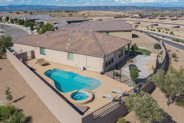 6417 Kings Cyn NE, Rio Rancho, NM 87144 - view of swimming pool featuring a fenced backyard, a patio, a pool with connected hot tub, and a mountain view