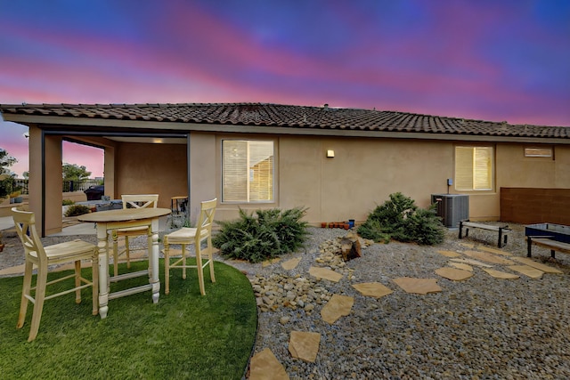 6417 Kings Cyn NE, Rio Rancho, NM 87144 - back of house at dusk with a patio area, a tiled roof, and stucco siding