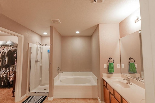 148 El Camino Loop NW, Rio Rancho, NM 87144 - full bath featuring a bath, a shower stall, a walk in closet, vanity, and tile patterned flooring