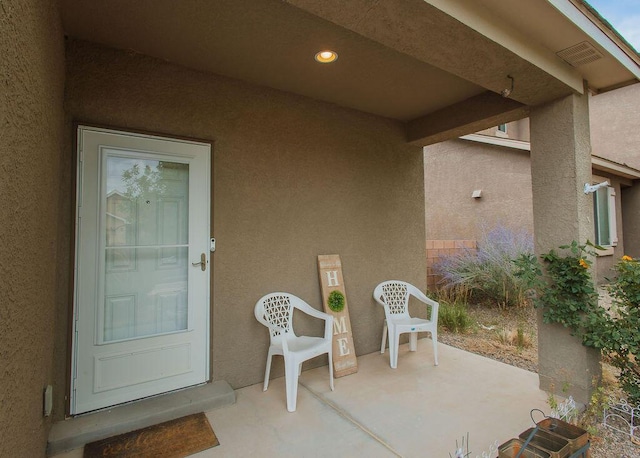 148 El Camino Loop NW, Rio Rancho, NM 87144 - view of exterior entry with stucco siding and a patio