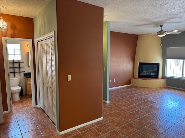 5400 Pegasus Dr NW, Albuquerque, NM 87120 - hallway featuring a textured ceiling, dark tile patterned flooring, and a chandelier