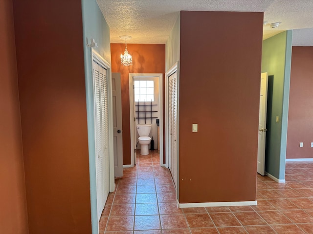 5400 Pegasus Dr NW, Albuquerque, NM 87120 - hall with tile patterned floors, a textured ceiling, and a chandelier