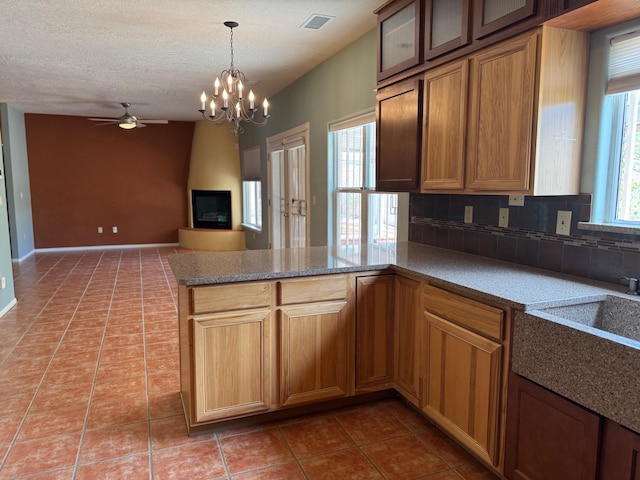 5400 Pegasus Dr NW, Albuquerque, NM 87120 - kitchen featuring ceiling fan, tile patterned flooring, a peninsula, a chandelier, and decorative light fixtures