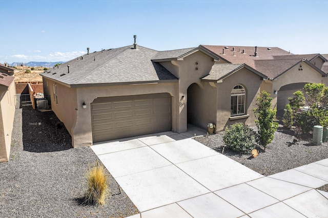4293 Crowned Eagle Loop NE, Rio Rancho, NM 87144 - view of front of property with an attached garage, stucco siding, driveway, a shingled roof, and a gate