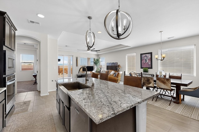 4293 Crowned Eagle Loop NE, Rio Rancho, NM 87144 - kitchen featuring a chandelier, appliances with stainless steel finishes, a ceiling fan, a kitchen island with sink, and pendant lighting
