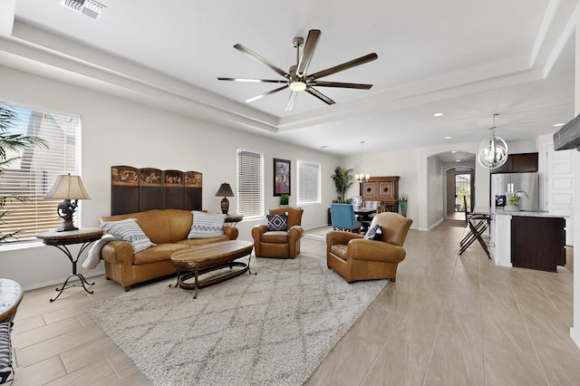 4293 Crowned Eagle Loop NE, Rio Rancho, NM 87144 - living area with a tray ceiling, arched walkways, recessed lighting, ceiling fan, and a chandelier