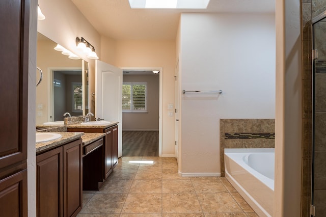 959 Salt Cedar Ct, Bernalillo, NM 87004 - bathroom with double vanity, a garden tub, a skylight, and a tile shower