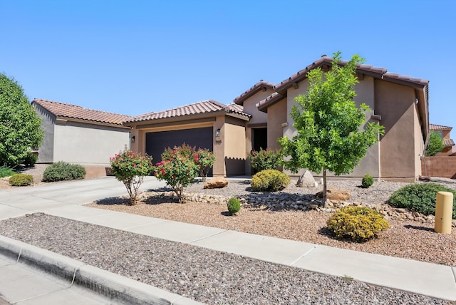 9015 Vista Dibujo Rd, Albuquerque, NM 87120 - mediterranean / spanish home featuring stucco siding, an attached garage, a tiled roof, and concrete driveway