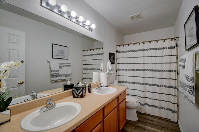 7024 Tree Line Ave NW, Albuquerque, NM 87114 - full bathroom with wood finished floors, double vanity, a textured ceiling, and curtained shower