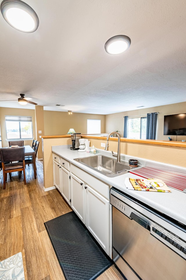 2900 Vista Del Rey NE Unit 18D, Albuquerque, NM 87112 - kitchen with dishwasher, light wood-type flooring, white cabinetry, light countertops, and plenty of natural light