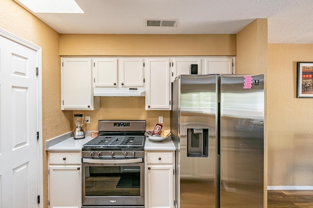 2900 Vista Del Rey NE Unit 18D, Albuquerque, NM 87112 - kitchen with stainless steel appliances, under cabinet range hood, a textured wall, light countertops, and white cabinetry