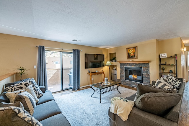 2900 Vista Del Rey NE Unit 18D, Albuquerque, NM 87112 - living area featuring wood finished floors, a textured ceiling, and a fireplace