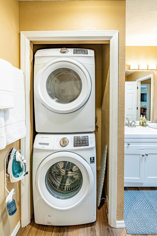 2900 Vista Del Rey NE Unit 18D, Albuquerque, NM 87112 - laundry area with stacked washer / dryer, wood finished floors, and a textured wall