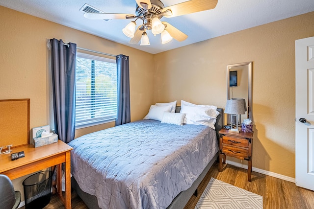2900 Vista Del Rey NE Unit 18D, Albuquerque, NM 87112 - bedroom with wood finished floors, a ceiling fan, and a textured wall