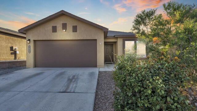2404 Del Timbre Ln SW, Albuquerque, NM 87121 - view of front facade featuring stucco siding, a garage, and driveway
