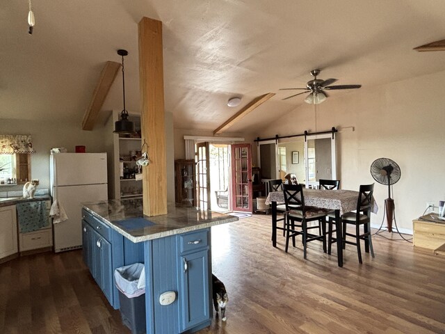 2 Bus Ln, Sandia Park, NM 87047 - kitchen with blue cabinetry, freestanding refrigerator, vaulted ceiling, a ceiling fan, and a barn door