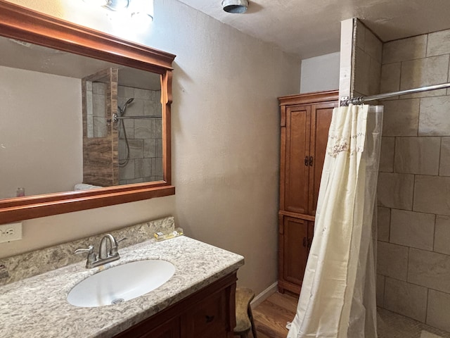 2 Bus Ln, Sandia Park, NM 87047 - bathroom with vanity, a tile shower, and wood finished floors