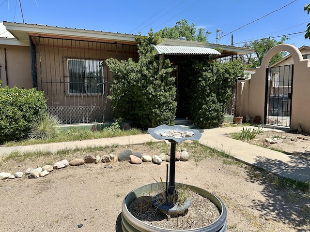 604 9th St SW, Albuquerque, NM 87102 - view of front of house featuring a metal roof, stucco siding, and a gate