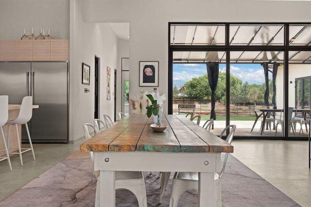400 Perea Ln, Corrales, NM 87048 - dining room featuring finished concrete floors, a towering ceiling, and expansive windows