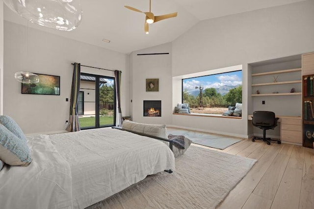 400 Perea Ln, Corrales, NM 87048 - bedroom featuring access to outside, a desk, high vaulted ceiling, hardwood / wood-style floors, and a lit fireplace