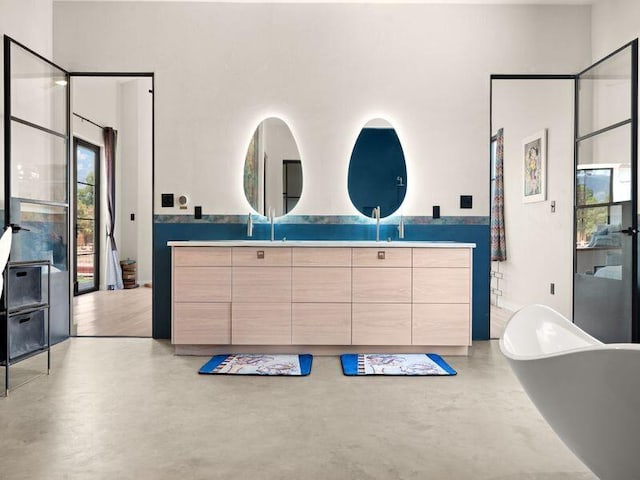 400 Perea Ln, Corrales, NM 87048 - bathroom featuring double vanity, finished concrete flooring, and a freestanding bath