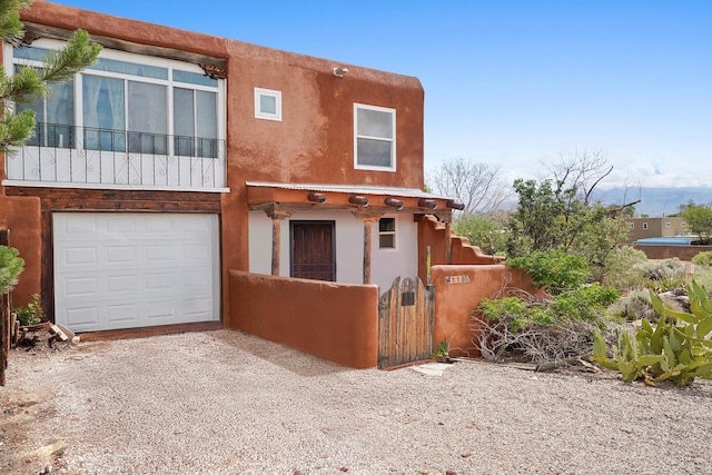 118 Sandia View Rd, Corrales, NM 87048 - view of front of property featuring a gate, stucco siding, gravel driveway, and an attached garage