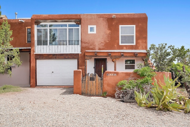118 Sandia View Rd, Corrales, NM 87048 - view of front of home with a gate, gravel driveway, and an attached garage