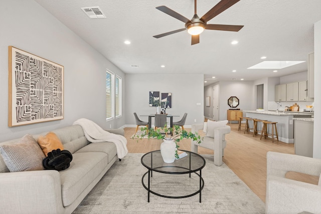 2520 Guadalupe Rd NE, Rio Rancho, NM 87144 - living room with light wood finished floors, recessed lighting, ceiling fan, and a skylight