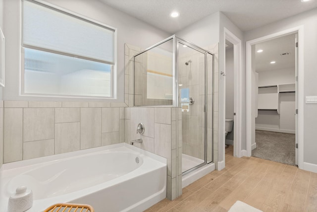 2520 Guadalupe Rd NE, Rio Rancho, NM 87144 - full bathroom featuring a garden tub, a stall shower, a spacious closet, wood finished floors, and recessed lighting