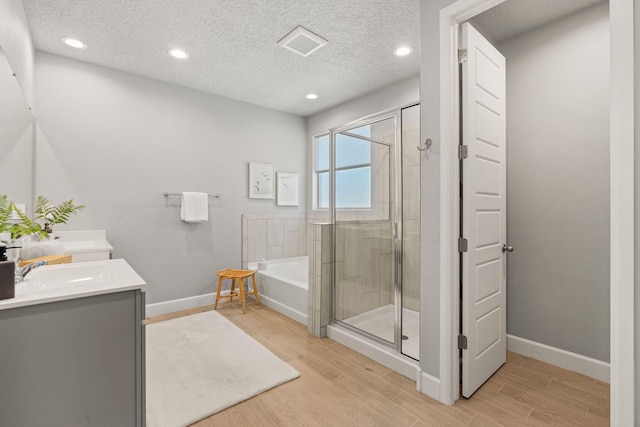 2520 Guadalupe Rd NE, Rio Rancho, NM 87144 - full bathroom with a bath, a shower stall, wood finished floors, double vanity, and recessed lighting