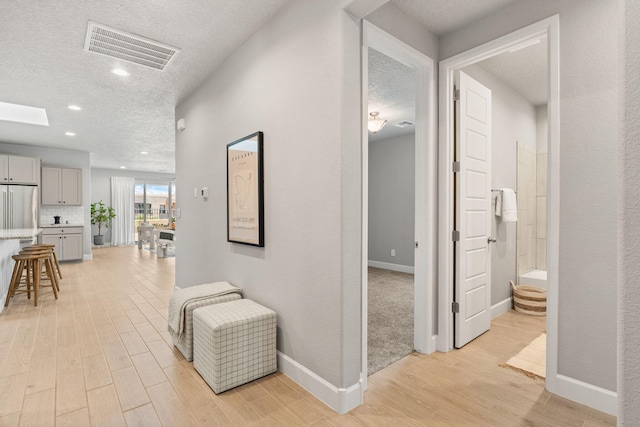 2520 Guadalupe Rd NE, Rio Rancho, NM 87144 - hall featuring light wood-type flooring, a textured ceiling, and recessed lighting