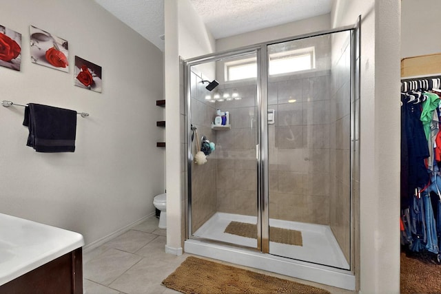 2332 Del Timbre Ln SW, Albuquerque, NM 87121 - full bathroom featuring a shower stall, a walk in closet, vanity, tile patterned floors, and a textured ceiling