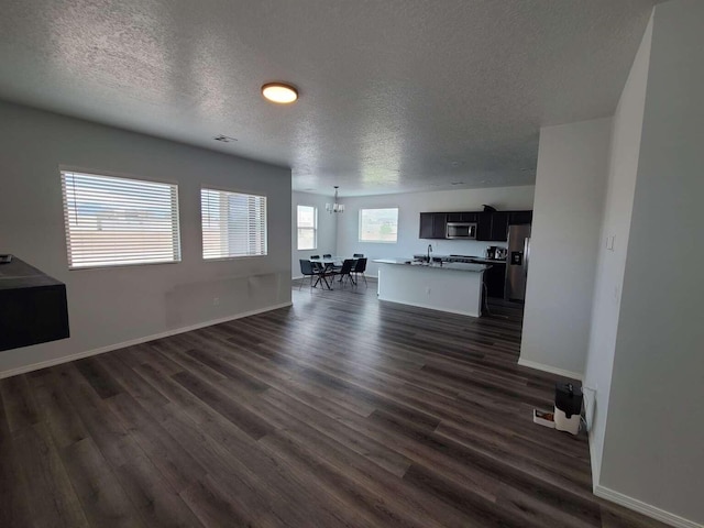 4300 Lauren NE, Rio Rancho, NM 87124 - living area with a textured ceiling, dark wood-style flooring, and a chandelier