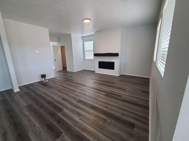 4300 Lauren NE, Rio Rancho, NM 87124 - unfurnished living room with a textured ceiling, a fireplace, and dark wood finished floors