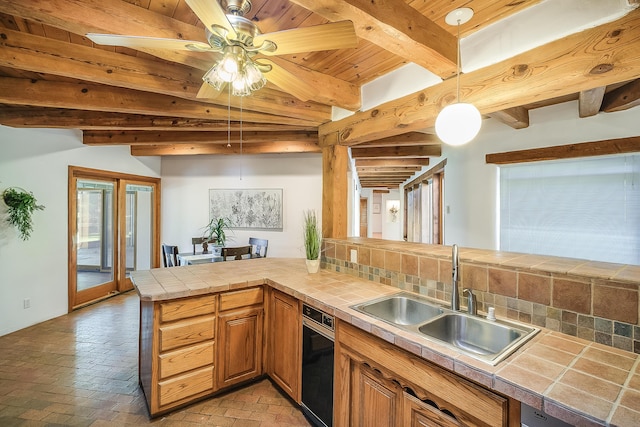 2505 Elfego Rd NW, Albuquerque, NM 87107 - kitchen with tile countertops, brick floors, pendant lighting, a ceiling fan, and a wooden ceiling with exposed beams