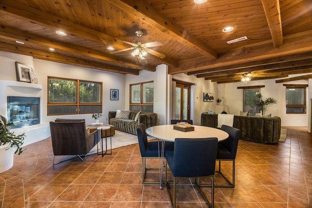 2505 Elfego Rd NW, Albuquerque, NM 87107 - tiled dining room with a ceiling fan, recessed lighting, a glass covered fireplace, and a wooden ceiling with exposed beams