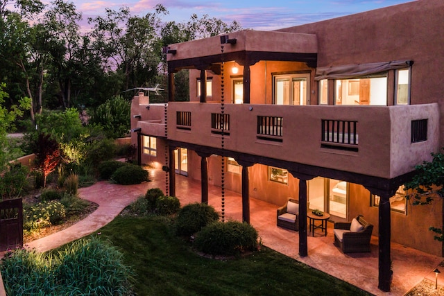 2505 Elfego Rd NW, Albuquerque, NM 87107 - back of house featuring a balcony, a patio area, an outdoor hangout area, and stucco siding