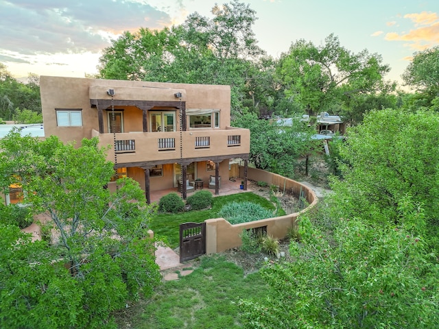 2505 Elfego Rd NW, Albuquerque, NM 87107 - rear view of property with a balcony, a patio area, stucco siding, and a gate