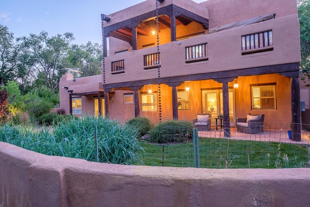 2505 Elfego Rd NW, Albuquerque, NM 87107 - back of property featuring a balcony, an outdoor hangout area, and a lawn