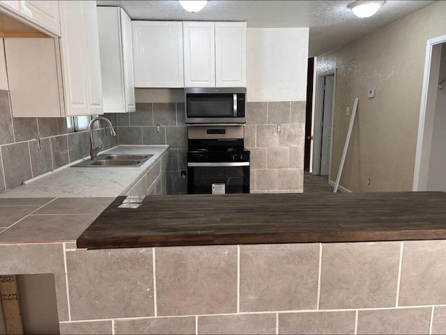 714 Locust St, Clayton, NM 88415 - kitchen featuring stainless steel appliances, white cabinets, and decorative backsplash