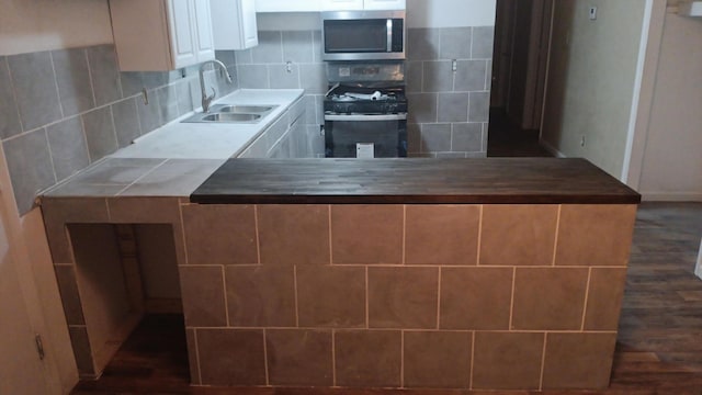 714 Locust St, Clayton, NM 88415 - kitchen with stainless steel microwave, black range with gas stovetop, dark wood-style floors, and backsplash
