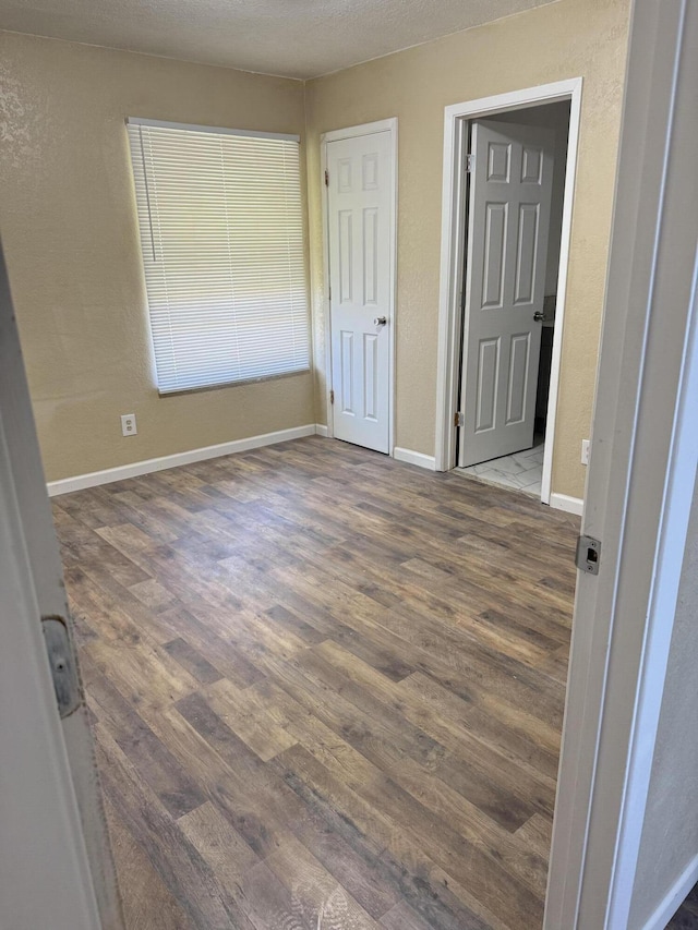 714 Locust St, Clayton, NM 88415 - unfurnished bedroom featuring wood finished floors and baseboards