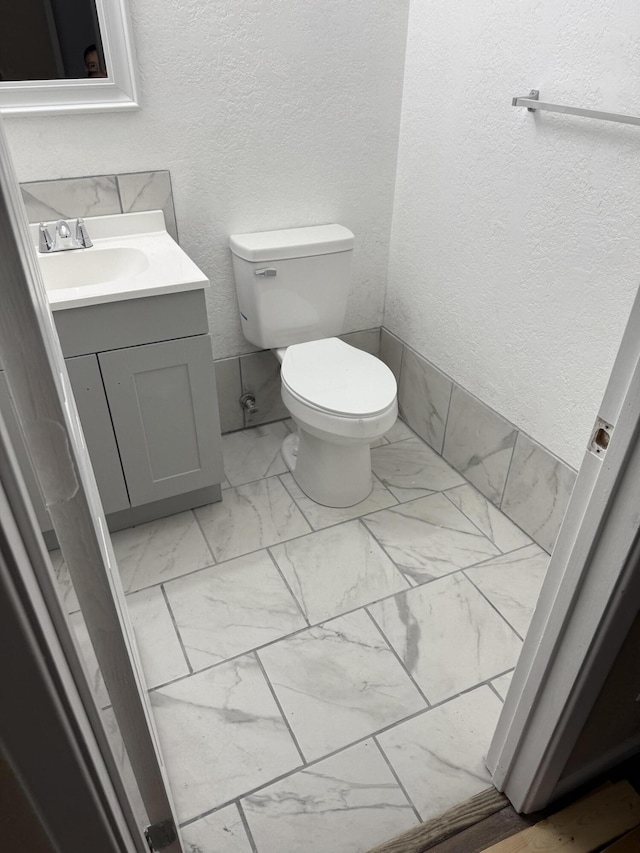 714 Locust St, Clayton, NM 88415 - half bath featuring marble look tiles, vanity, and a textured wall
