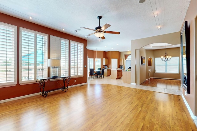 4104 Killington Rd NW, Albuquerque, NM 87114 - living room featuring light wood finished floors, a textured ceiling, a chandelier, healthy amount of natural light, and a ceiling fan