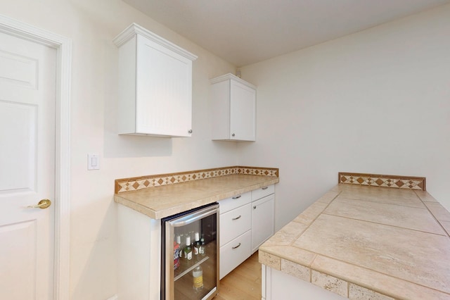 4104 Killington Rd NW, Albuquerque, NM 87114 - kitchen featuring beverage cooler, white cabinets, and light wood-style floors