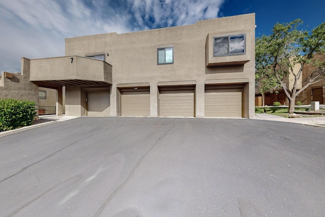 2900 Vista Del Rey NE Unit 7A, Albuquerque, NM 87112 - pueblo-style home featuring a balcony, driveway, stucco siding, and a garage