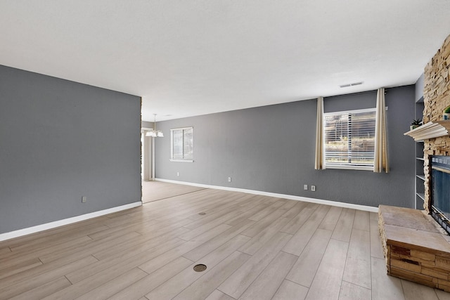 2900 Vista Del Rey NE Unit 7A, Albuquerque, NM 87112 - unfurnished living room featuring a glass covered fireplace, wood finished floors, and a chandelier