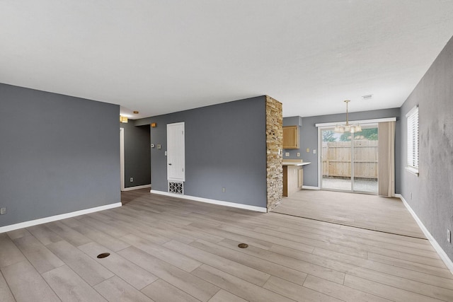 2900 Vista Del Rey NE Unit 7A, Albuquerque, NM 87112 - unfurnished living room featuring a chandelier and light wood-style flooring